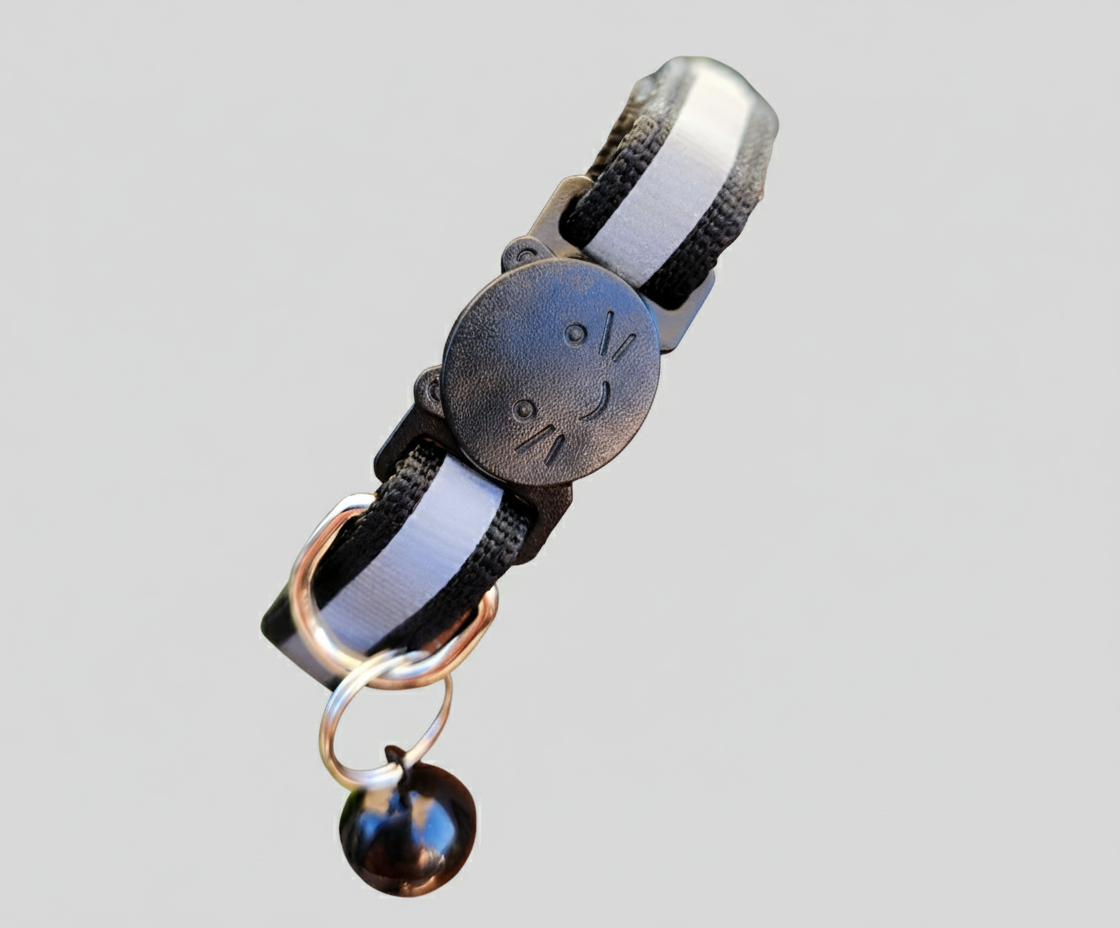 Cat collar with black and white striped design and a bell on a gray background